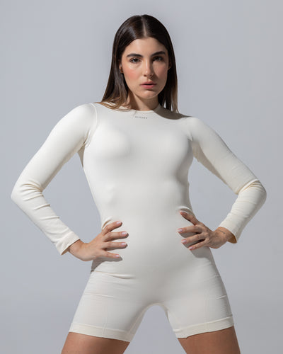Model wearing The Seamless Long Sleeve Onesie in cream with short legs, front view