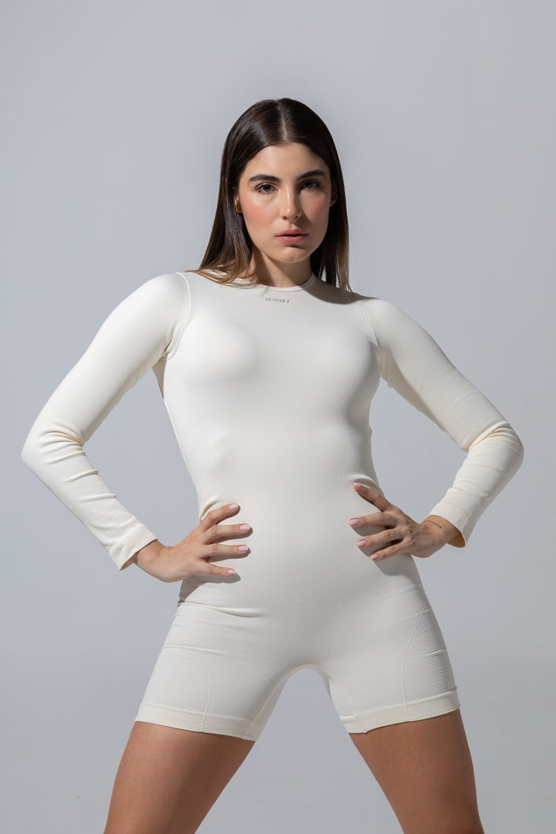 Model wearing The Seamless Long Sleeve Onesie in cream with short legs, front view