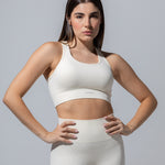 Model wearing The Seamless Bra Top in cream with matching cream leggings, front view