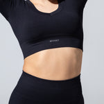 Close-up of The Seamless Crop Top in black showing the short sleeves and ribbed hem