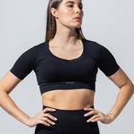 Model in The Seamless Crop Top in black, hands on hips, front view