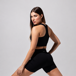 Model in a lunge wearing The Seamless Shorts in black, three-quarter back view