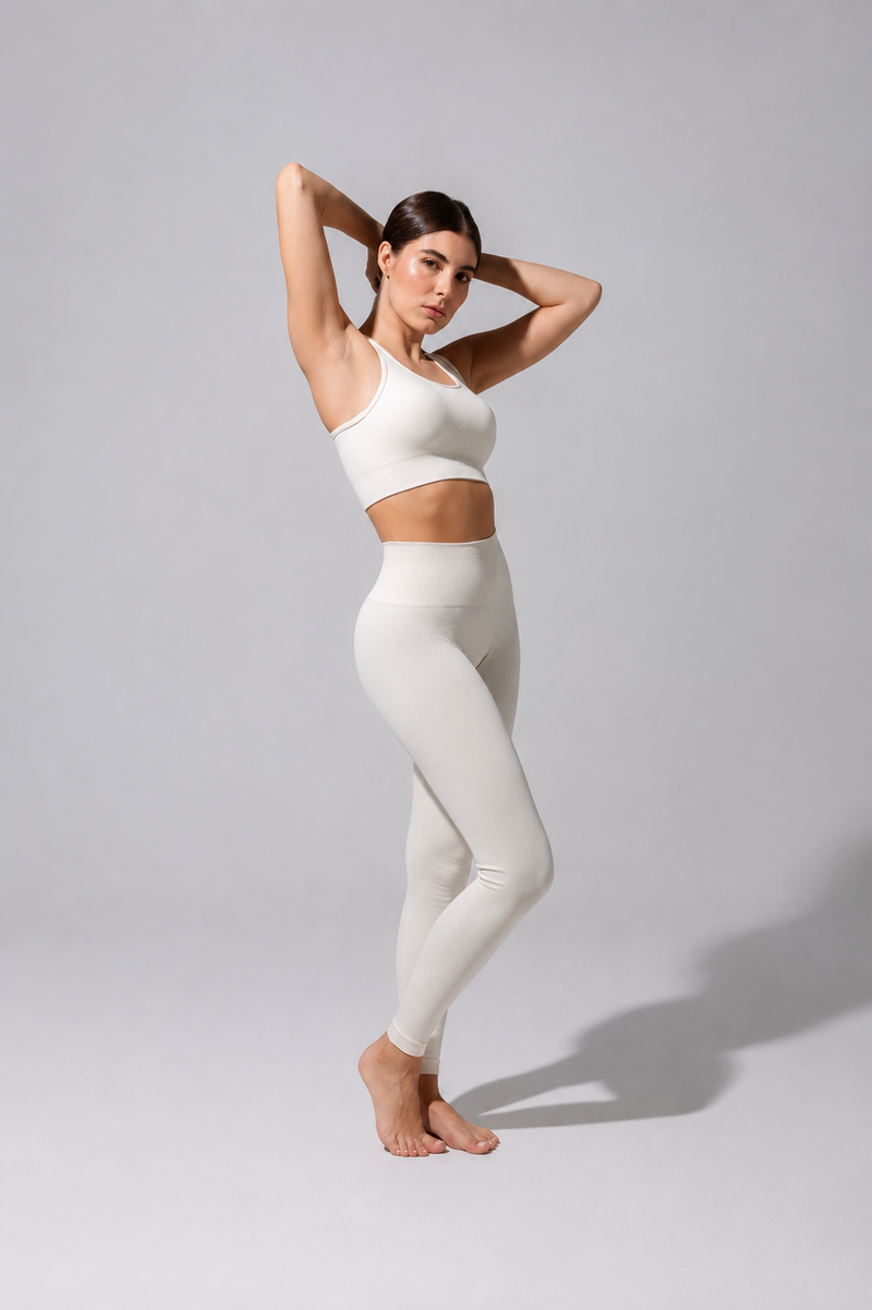 Model wearing The Seamless Legging in cream with a cream bra top, full-length three-quarter view